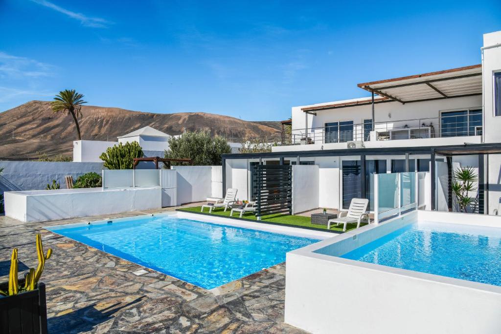 a villa with a swimming pool and a house at Casa Amanecer 3 in Mácher