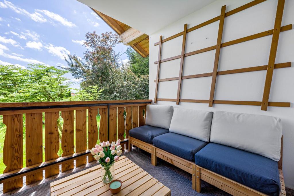 a porch with a bench and a vase of flowers at Ferienwohnung mit Bergblick in Edling