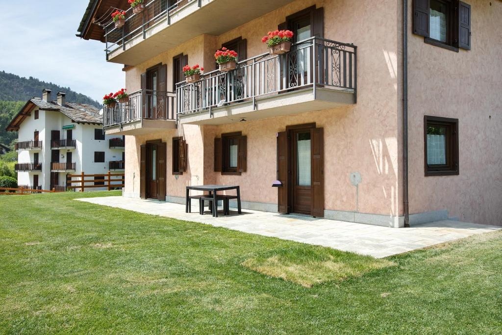 a building with two balconies and a table in a yard at Maison Le Cré Appartamento 2 in Introd