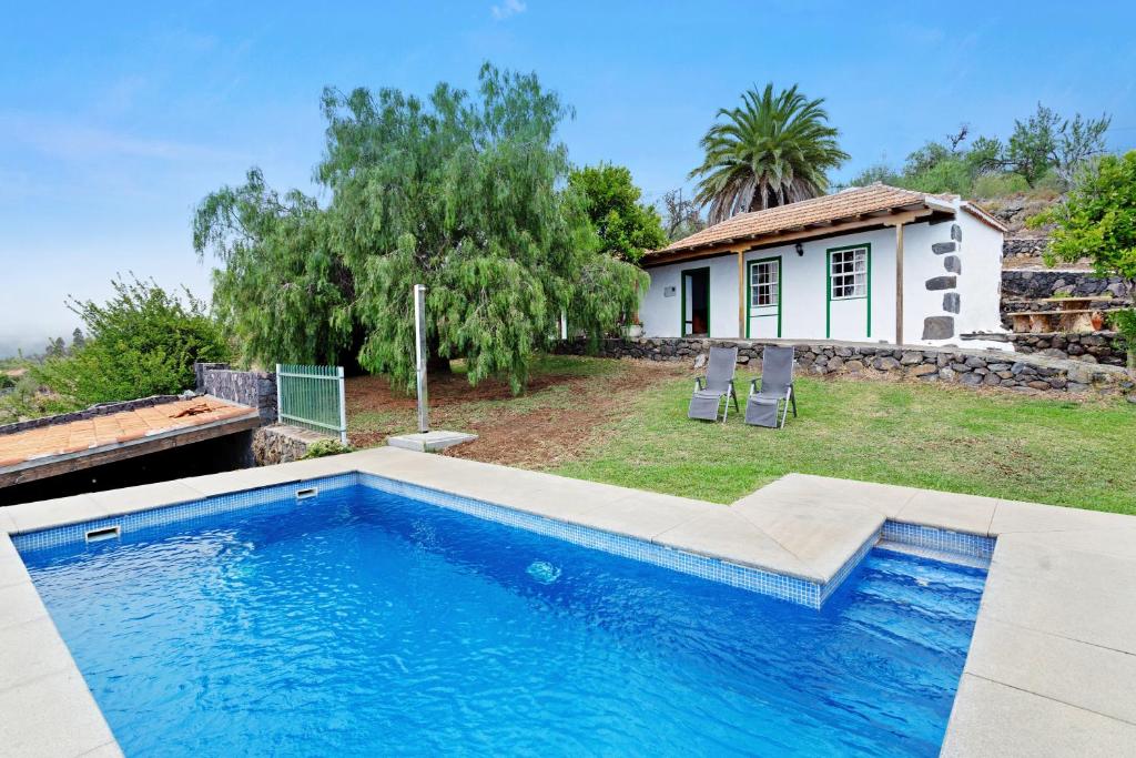 a swimming pool in front of a house at Casa Serradero in Tijarafe