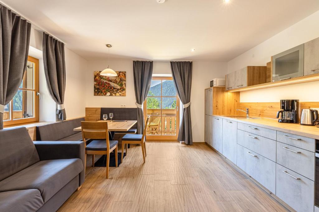a kitchen and living room with a couch and a table at Lechnerhof Wilde Kreuzspitze in Valles