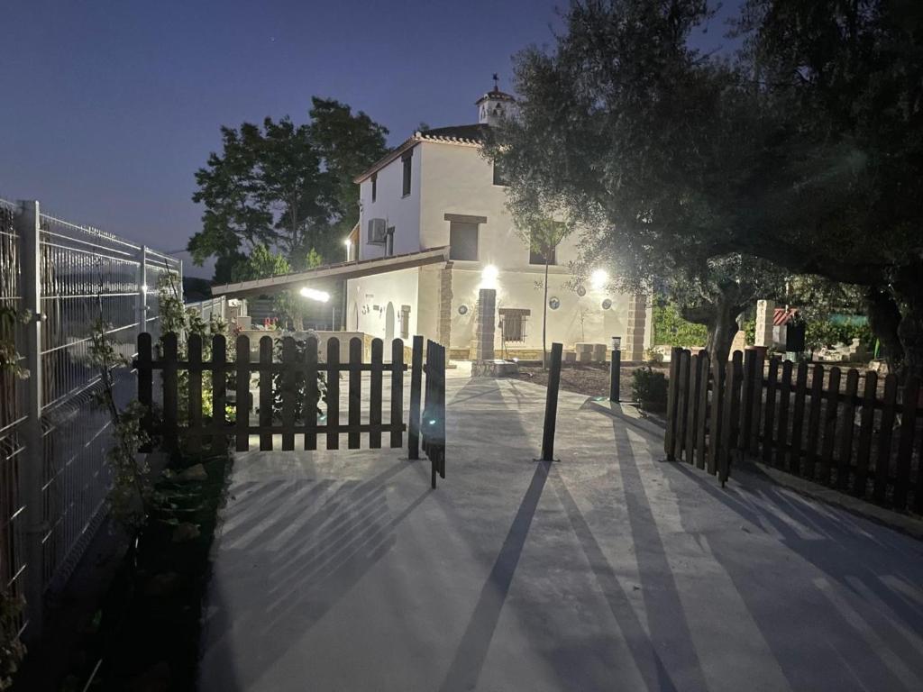a fence in front of a white building with a house at Casa de Antonio con piscina privada in Moratalla