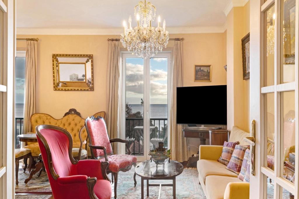 a living room with a chandelier and a tv at Bela Sao Tiago 36 in Funchal
