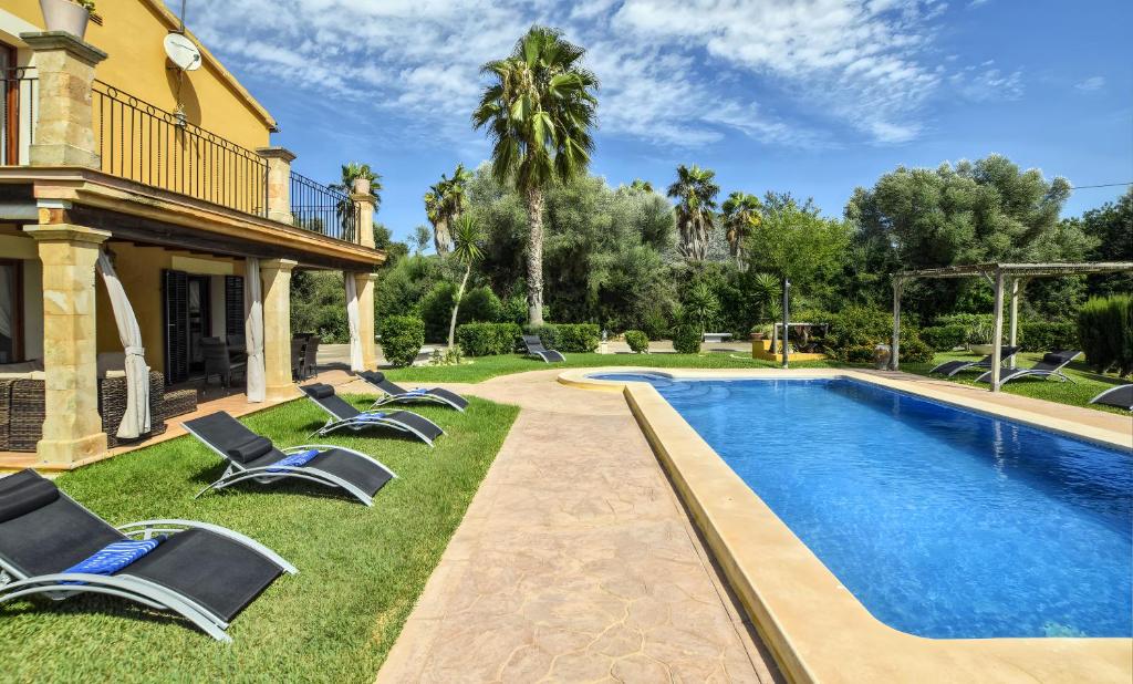 a pool with lounge chairs next to a house at Ines in Inca