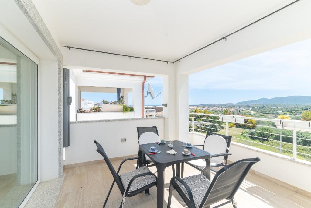 a dining room with a table and chairs on a balcony at Casa Virgi vista mare in Budoni