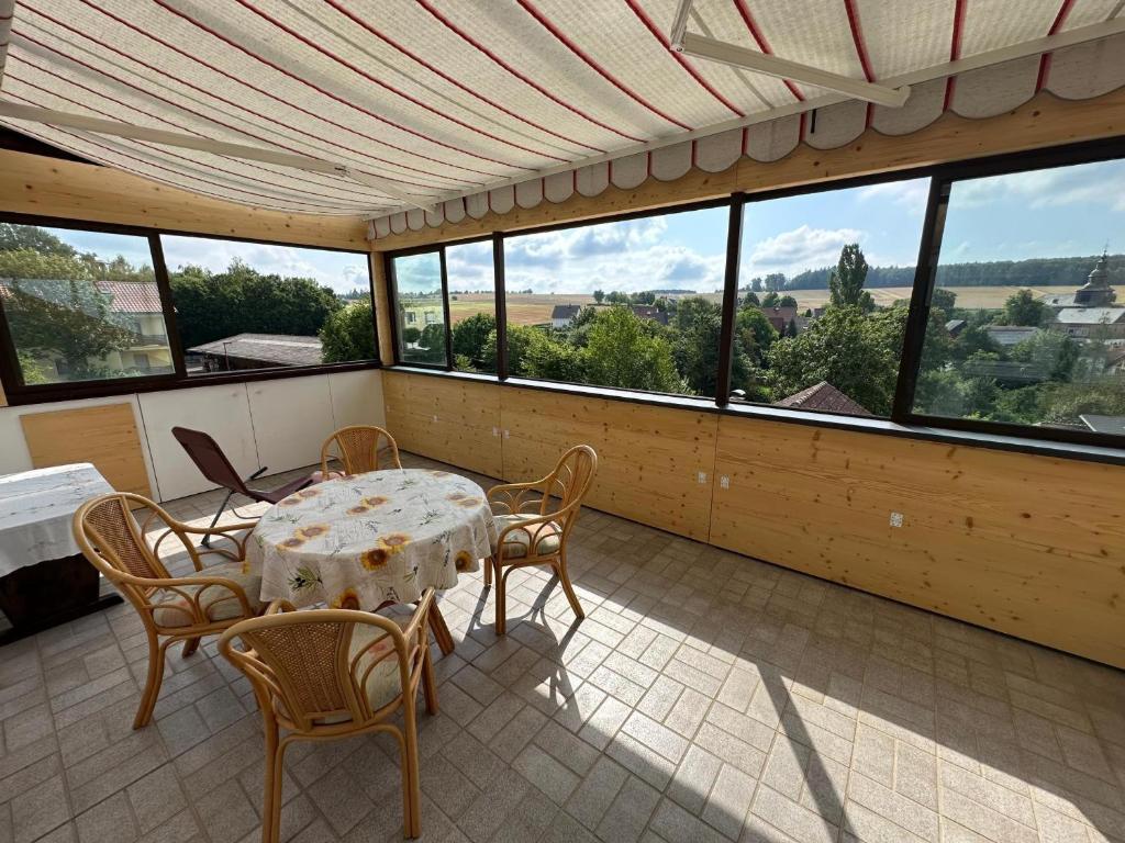 a screened in porch with a table and chairs at Ferienwohnung Taunusnest in Limbach