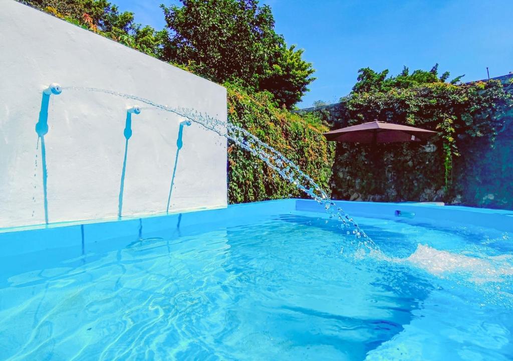 a swimming pool with a water fountain at Casa Maya Villa with Private Pool Bar and Parking Merida in Mérida
