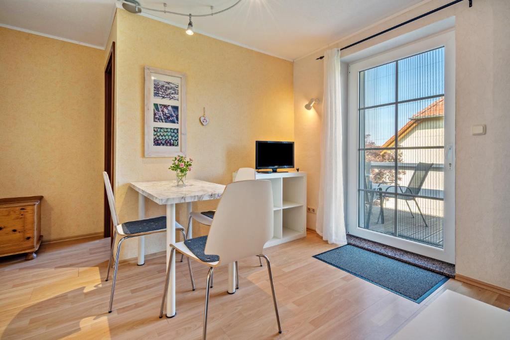 a living room with a table and chairs and a window at Ferienwohnung 1 Schulze in Neustrelitz