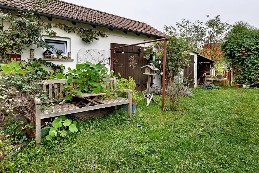 a garden with a bench in front of a house at Sleep And Go in Mundelsheim