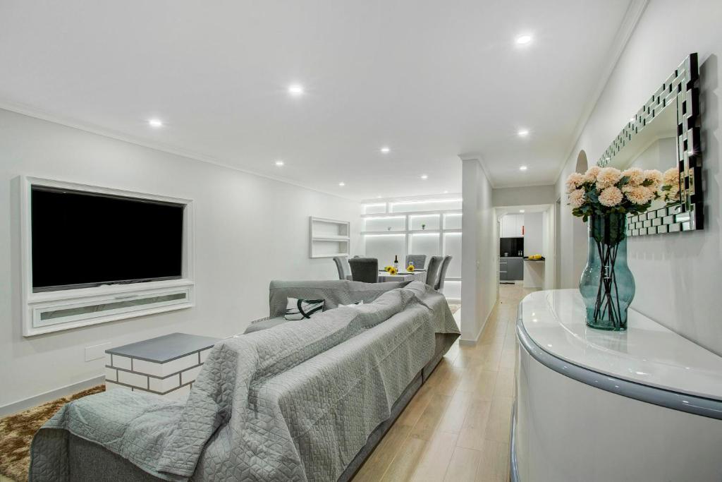a living room with a couch and a tv at Alegria Dream Home in Funchal