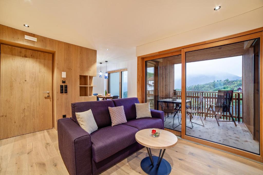 a living room with a purple couch and a table at Huetterhof Apartement Winter in Caines