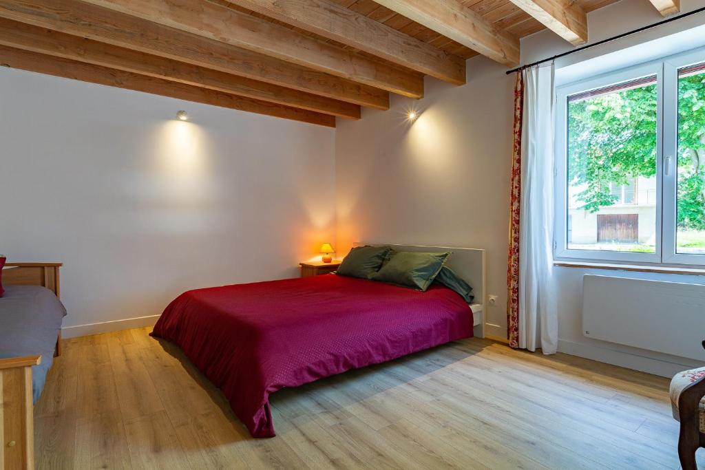 a bedroom with a bed and a large window at L'Arche aux Peyruches in Assieu