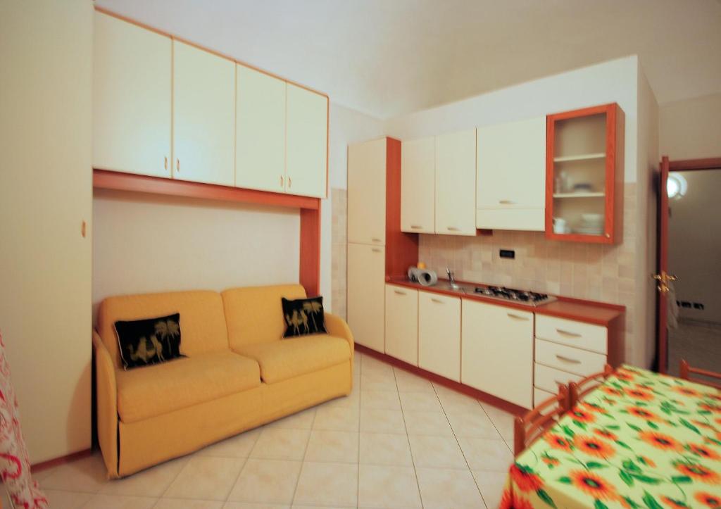 een woonkamer met een bank en een keuken bij Monolocale GARIBALDI in Loano