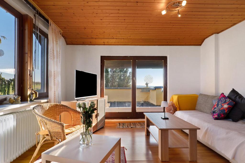a living room with a couch and a tv at Ferienwohnung Schöne Aussicht in Gemmrigheim