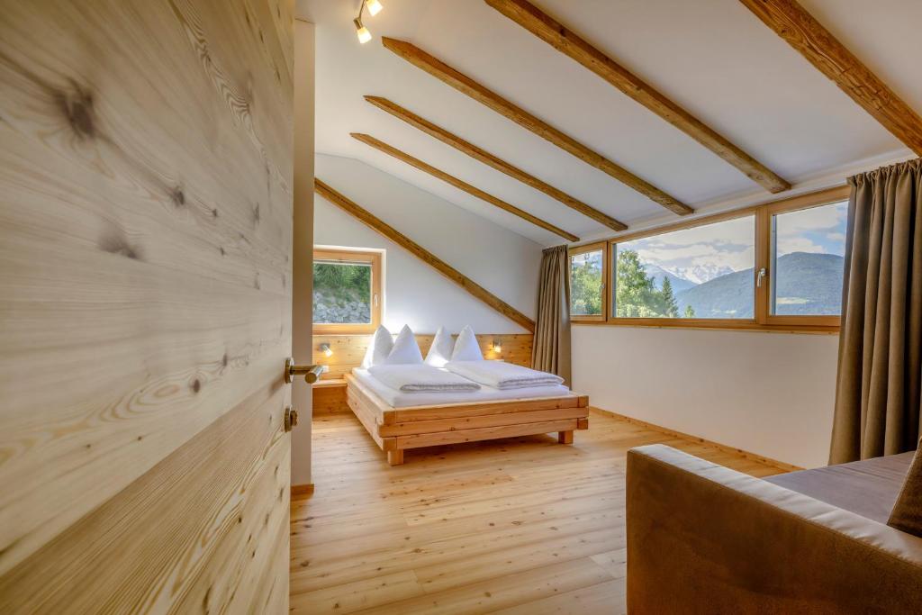 a bedroom with a bed and a window at Vernalhof Apt Panorama in Sluderno