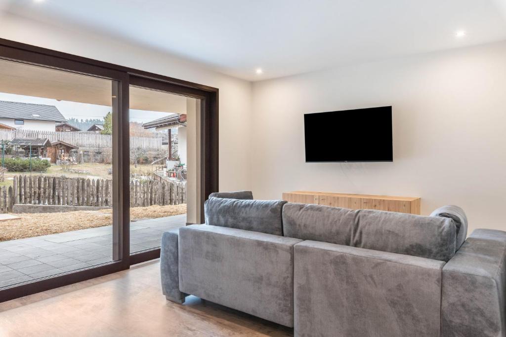 a living room with a couch and a flat screen tv at Villa Lara Zirbe in Castelrotto