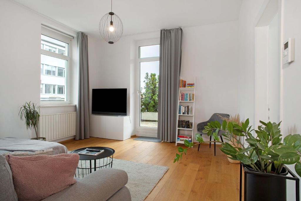 a living room with a couch and a tv at Zeitlos Zuhause Bregenz in Bregenz