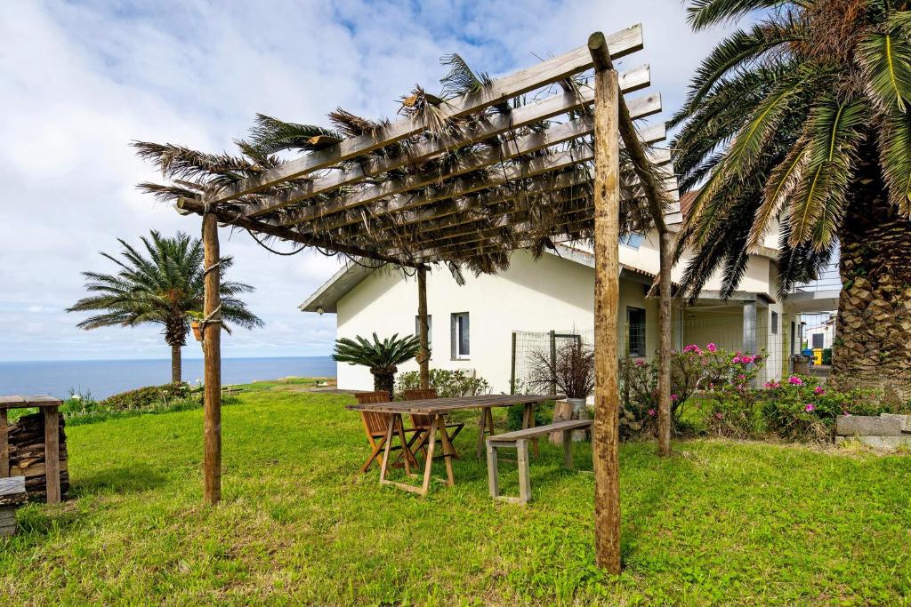 a picnic table in front of a house at Casinha do Monte in Achadinha