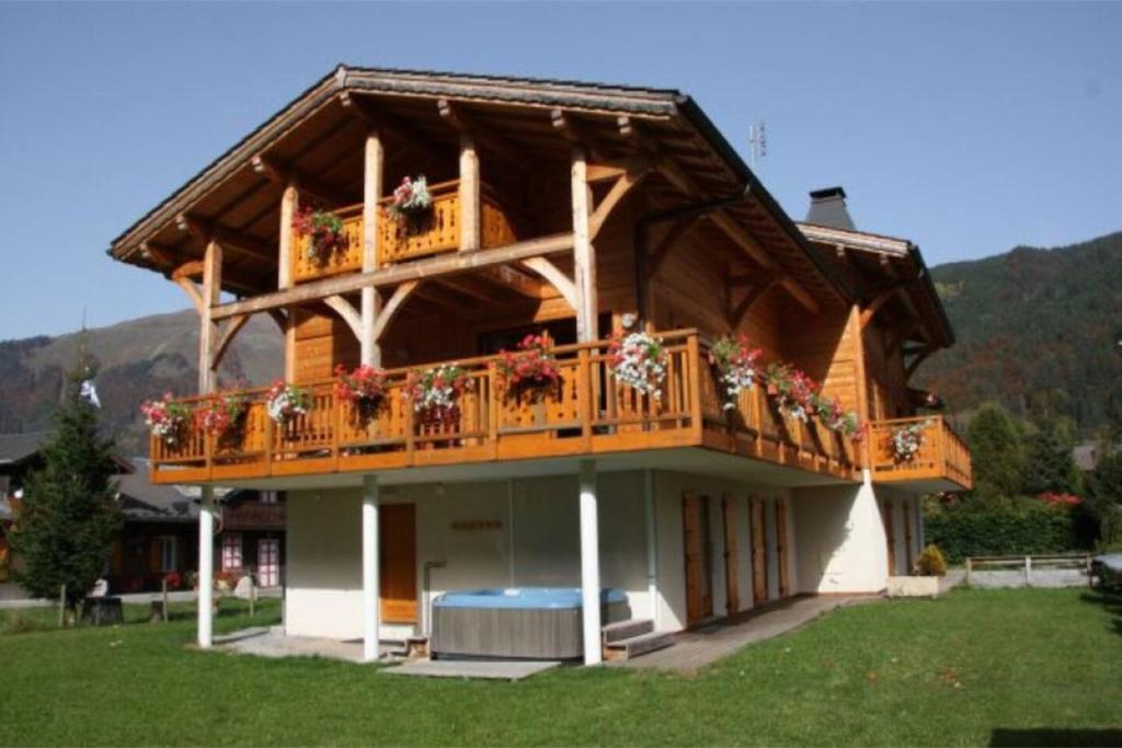 a house with a balcony with flowers on it at Chalet Myrtille in Morzine