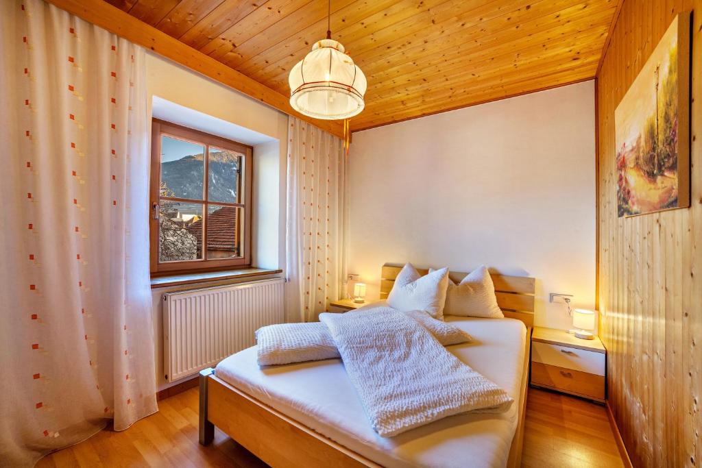 a bedroom with a white bed and a window at Wohnung Elstar Schnalserhof in Laces