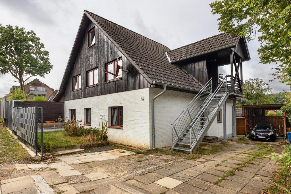 a house with a black and white roof at Gemütliche Wohnung Buchholz i d N in Buchholz in der Nordheide