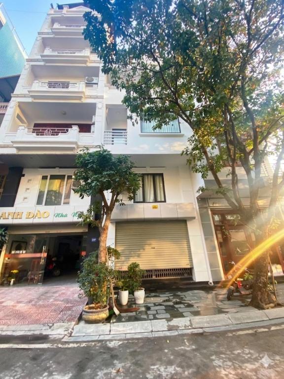 a white building with trees in front of it at Anh Đào 2 Hotel in Hai Phong