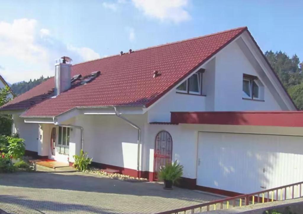 a white house with a red roof at Ferienwohnung Haus Waldfee in Sulzburg