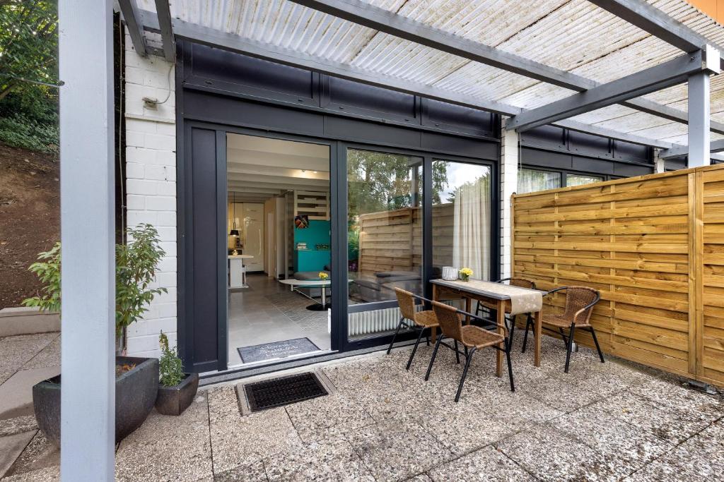 a glass extension of a house with a table and chairs at Apartment am Wald in Dörentrup