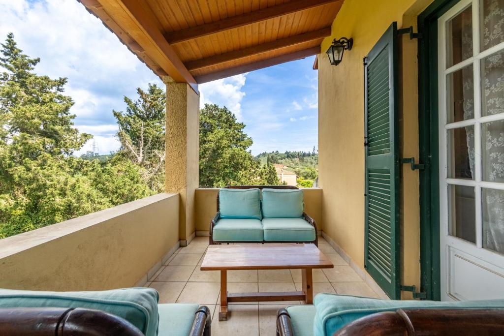 a porch with two blue chairs and a table at Blue apartment Corfu in Perivólion