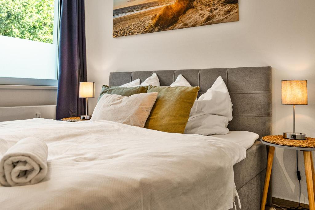 a bedroom with a large white bed with pillows at Studio Apartment am Kurpark in Bad Segeberg