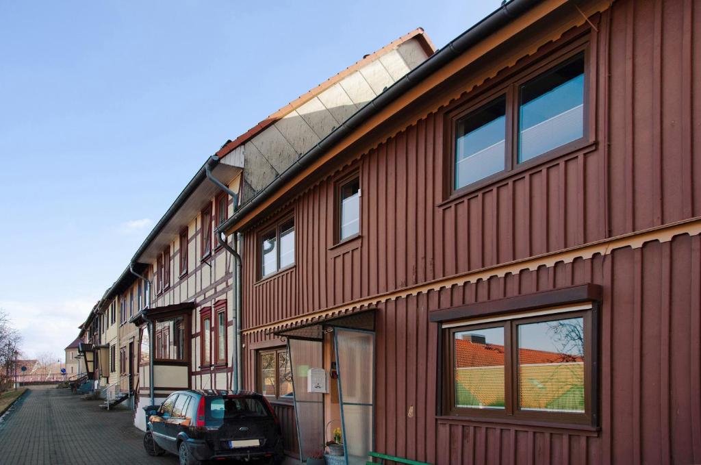 a red building with a car parked next to it at Am Graben in Hasselfelde