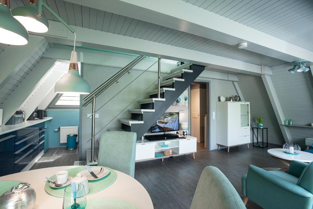 a living room with a staircase and a table and chairs at Ferienhaus Waldperle in Ronshausen