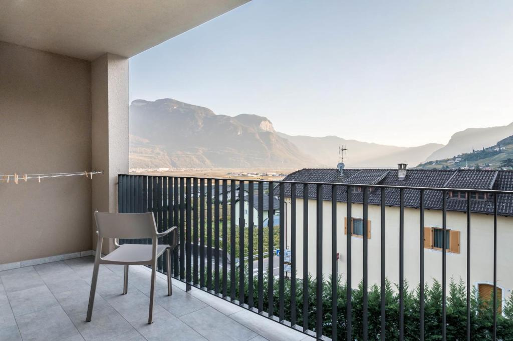 a balcony with a chair and a view of the mountains at Ferienwohnungen Karin - Merlot in Termeno
