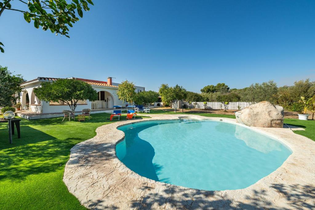 a swimming pool in a yard with a house at Villa Mavi in Quartucciu