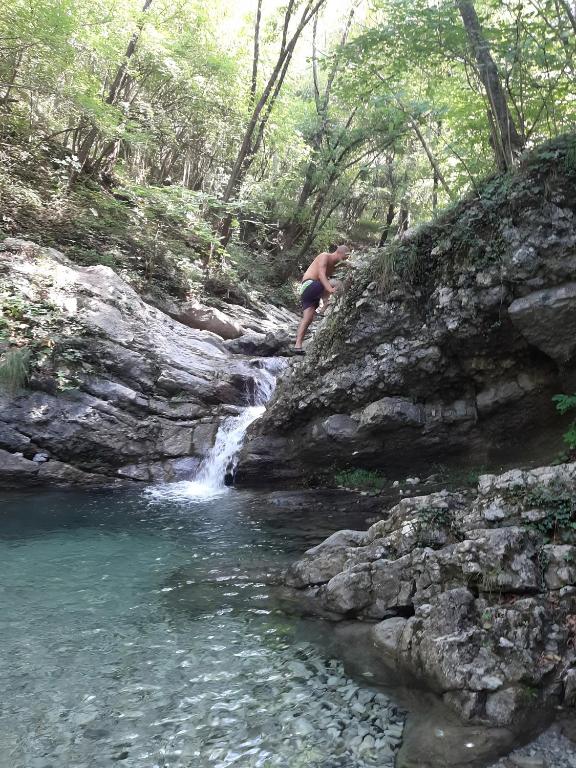 a man standing on a rock next to a waterfall at Family House Il Butto in Erve