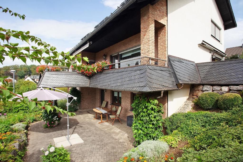 a balcony of a house with a table and an umbrella at Ruhrtalblick in Bestwig