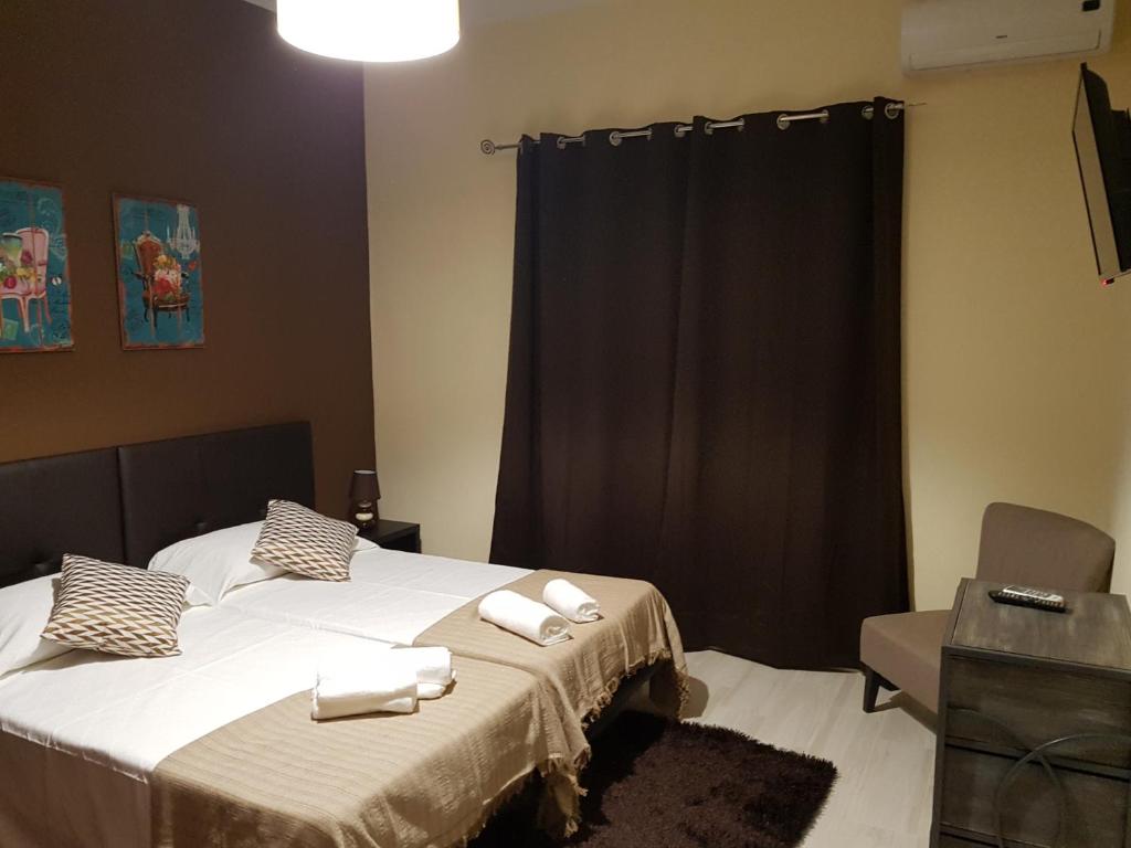 um quarto com 2 camas e toalhas brancas em Almancil Hostel em Almancil