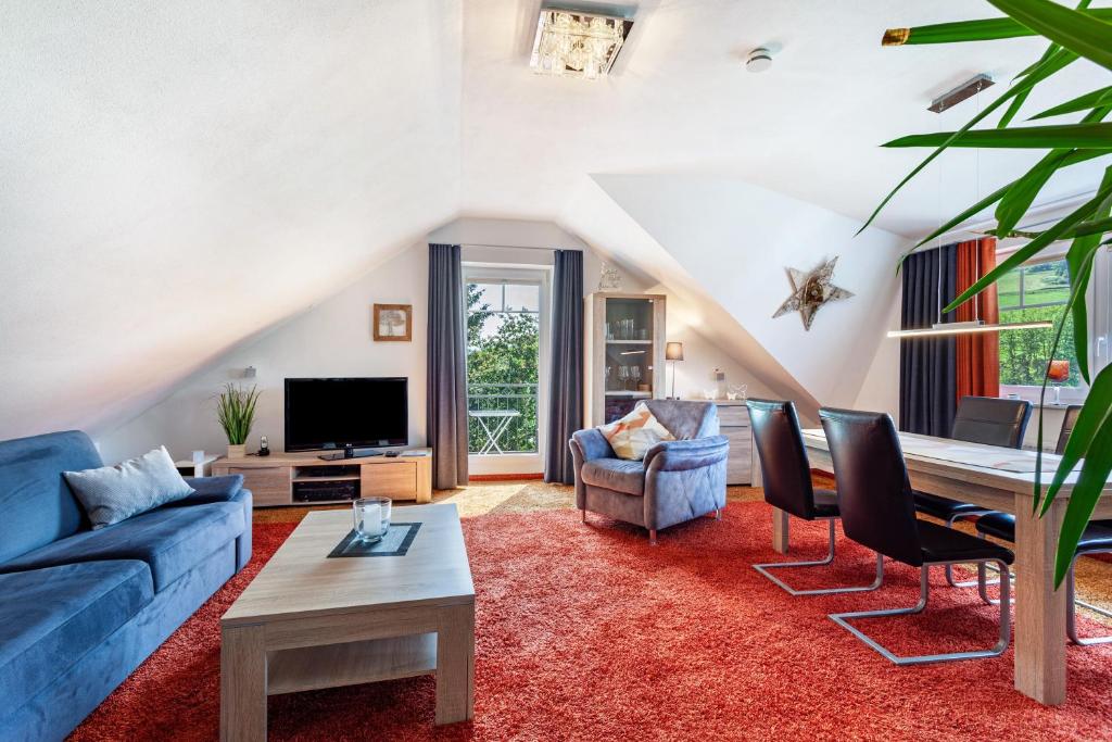 a living room with a blue couch and a table at Haus Schönblick - "Fewo Sarina 2" in Willingen