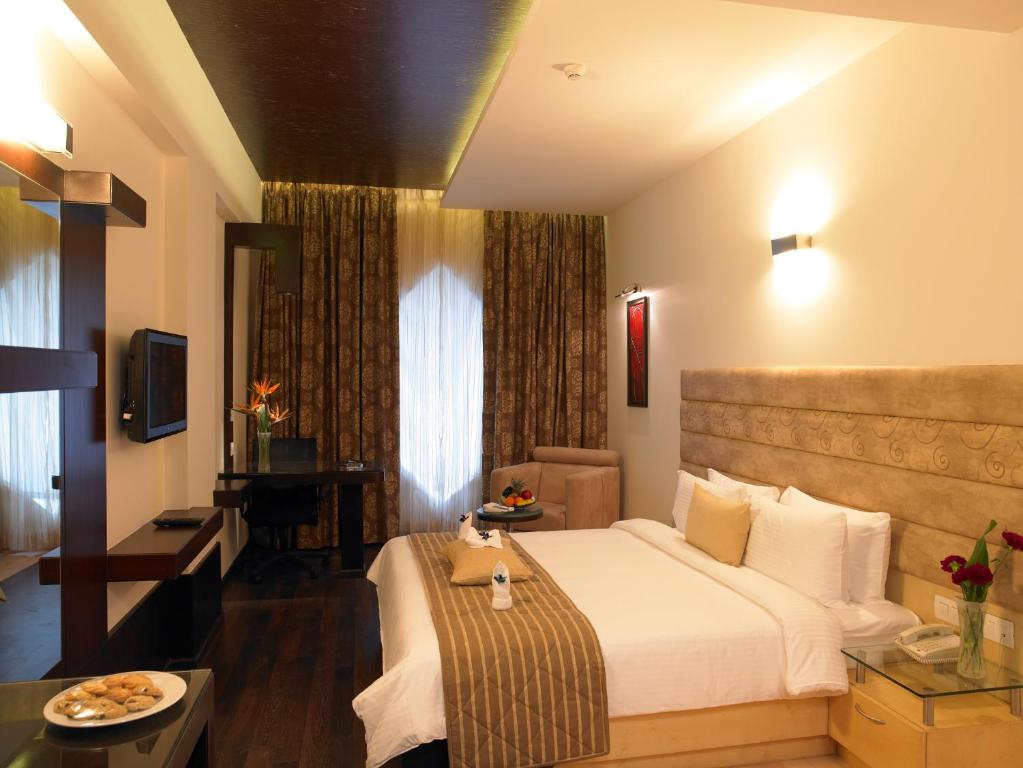 a hotel room with a bed and a table at Blu Petal - A Business Hotel in Bangalore