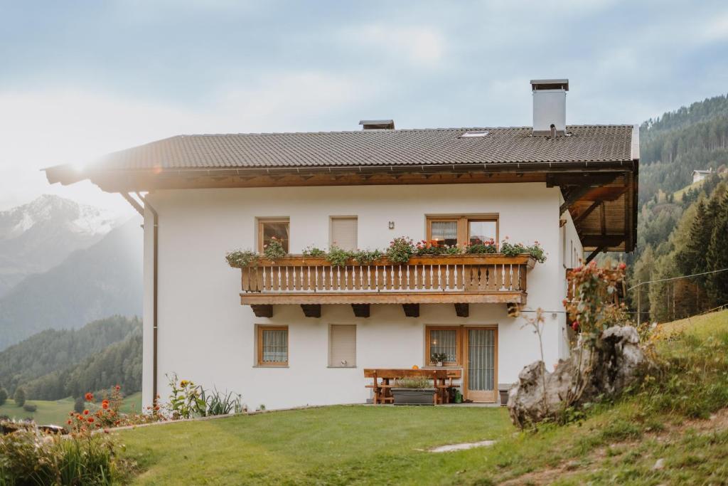 a white house with a balcony on a hill at Hienerhof in Moso