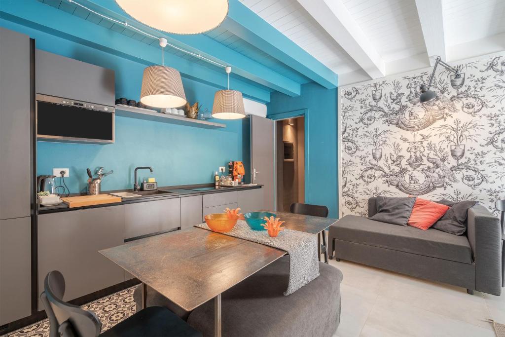 a kitchen and living room with a table and a couch at Ortigiadreamrooms 12 in Syracuse