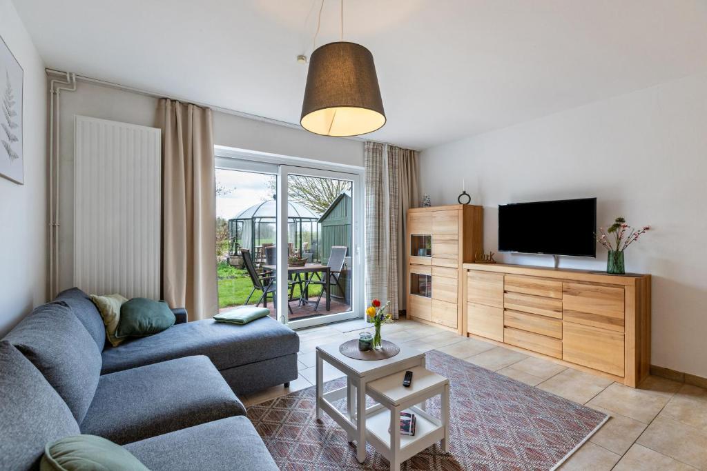 a living room with a couch and a tv at Gartenglückchen in Lindhöft