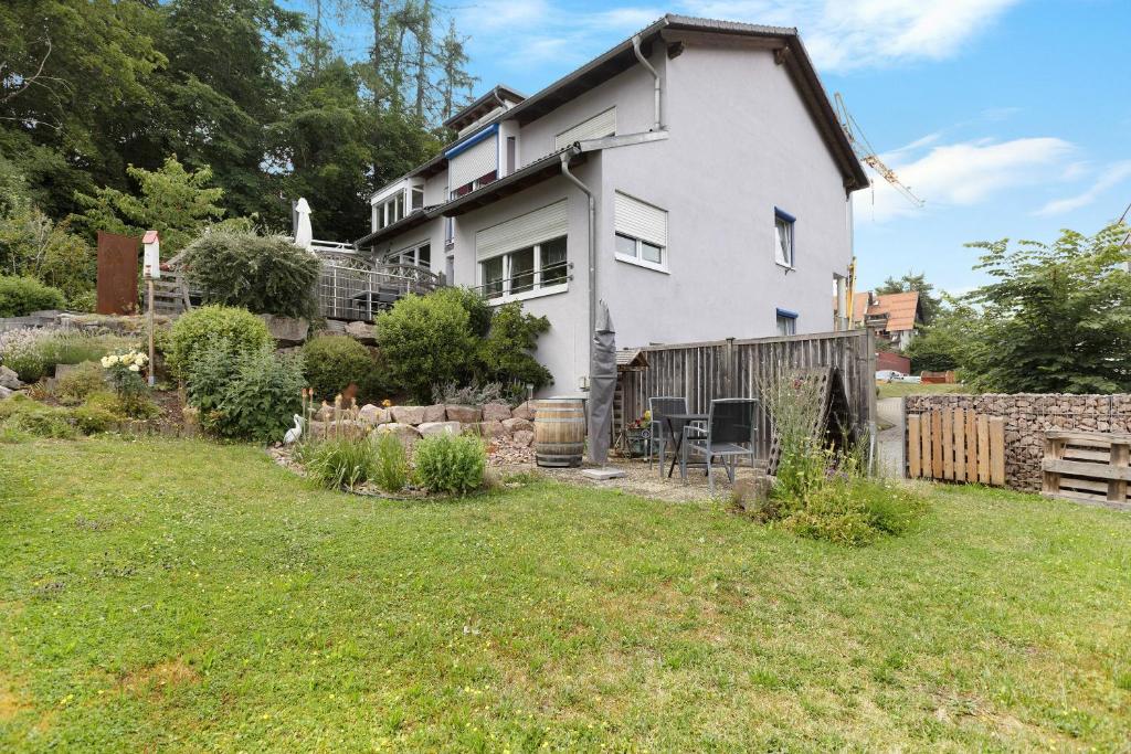 a white house with a fence and a yard at Ferienwohnung Im Bohrer in Donaueschingen