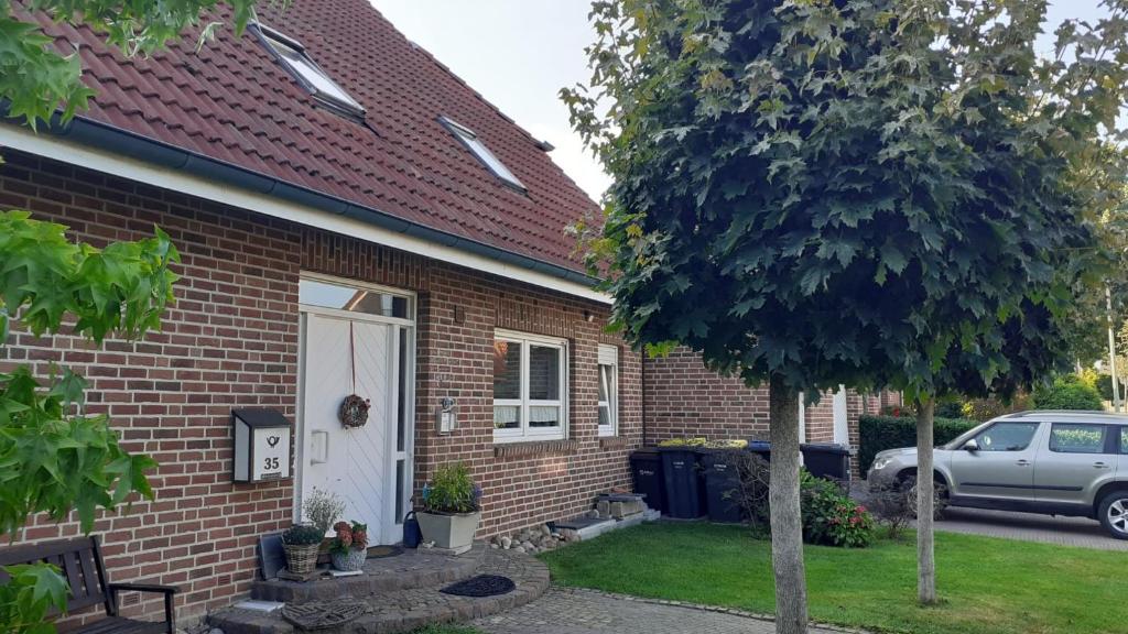 a brick house with a white door and a car at Kiepe im Münsterland in Nordwalde
