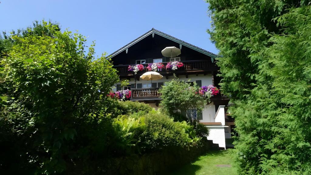 a house with a balcony with flowers on it at Haus Elbrächter - Erdgeschoss in Gstadt am Chiemsee