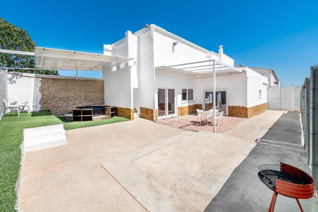 a white house with a patio and lawn at La Bombonera 2 in Catadau