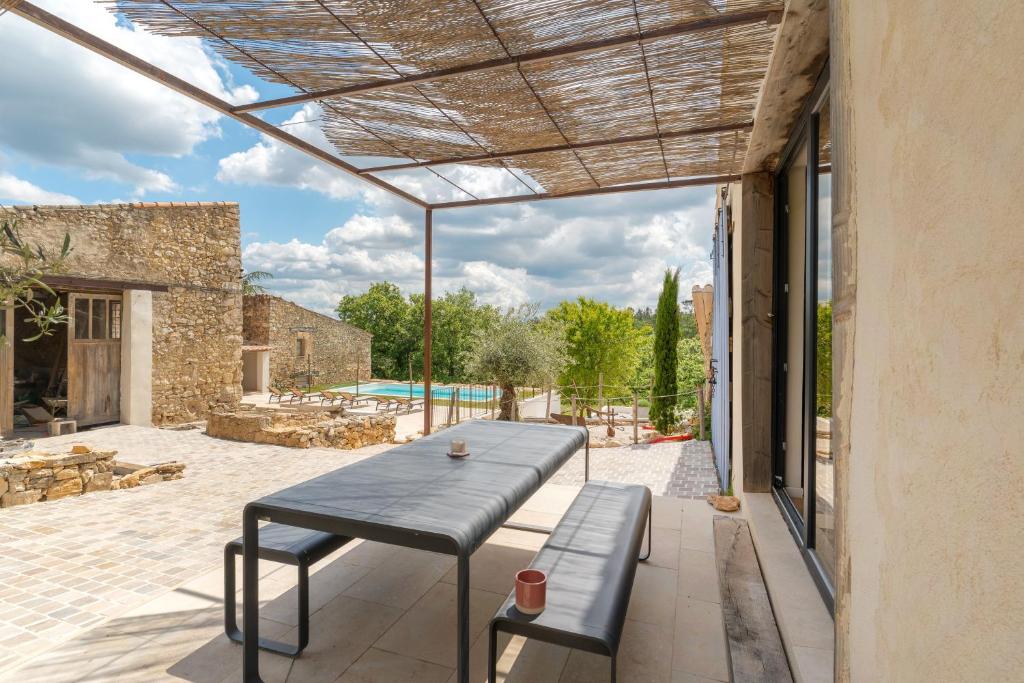 an outdoor patio with a bench and a table at Le Loft in Esparron