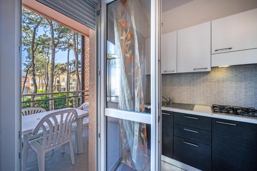 a kitchen with a sliding glass door leading to a balcony at Appartamento Andromeda B4 in Bibione