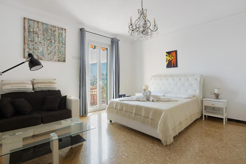 a white bedroom with a bed and a couch at Casa Merlino in Biassa