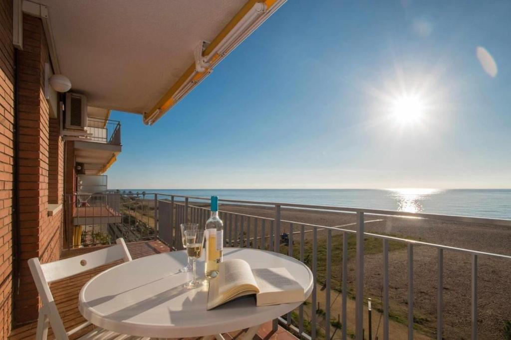 a table on a balcony with a view of the ocean at Maresme Beach Apartment in Canet de Mar
